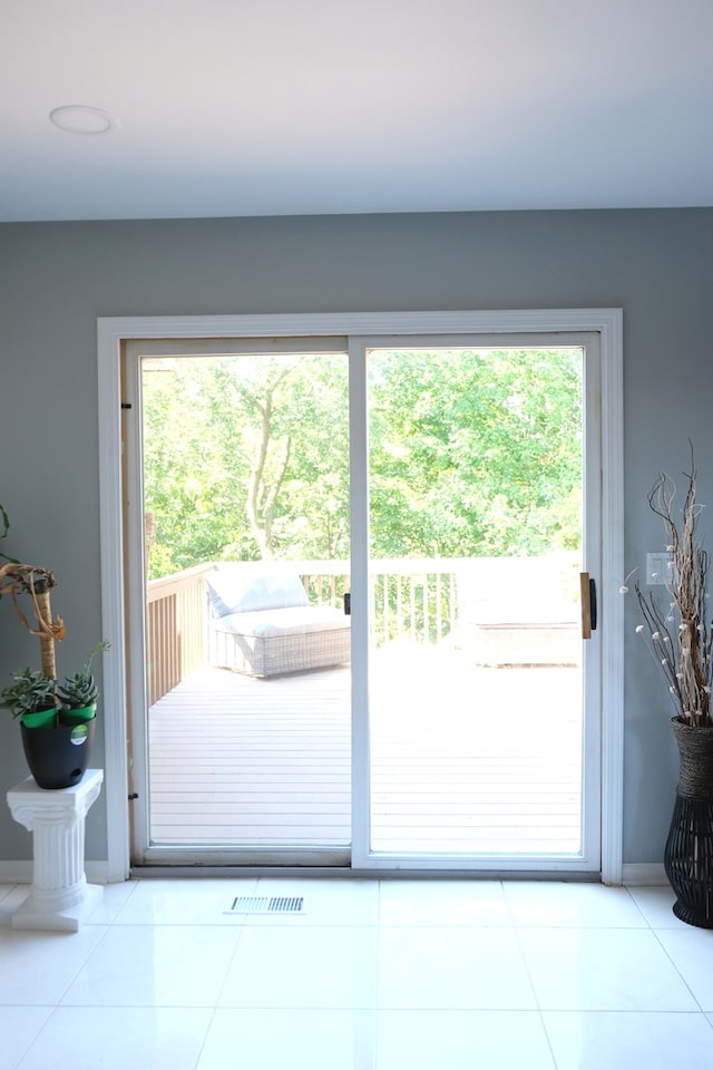 doorway with light tile patterned floors and a wealth of natural light