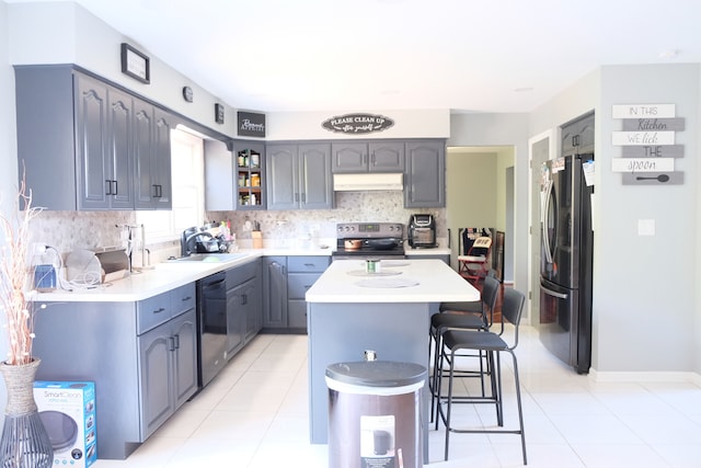 kitchen featuring a breakfast bar area, sink, a center island, appliances with stainless steel finishes, and tasteful backsplash