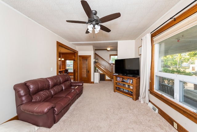 carpeted living room featuring ceiling fan, a healthy amount of sunlight, and a textured ceiling