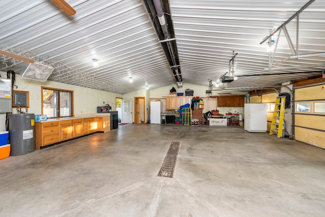 garage with a garage door opener, white fridge, and electric water heater