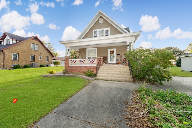 view of front of property featuring a front lawn, central air condition unit, and a porch