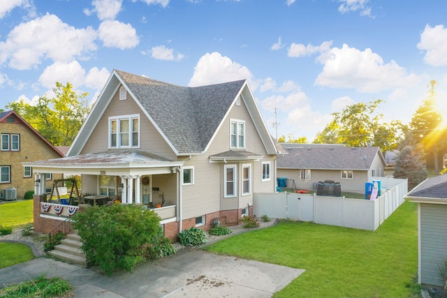 back of house featuring central AC, a lawn, and a porch