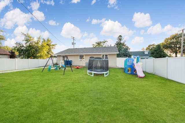 back of property featuring a yard, a trampoline, and a playground