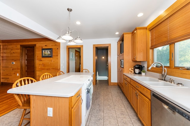 kitchen with wood walls, sink, a kitchen island, stainless steel dishwasher, and a breakfast bar