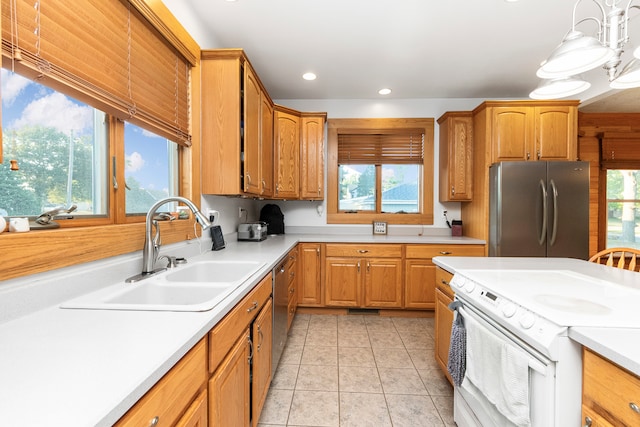 kitchen featuring sink, white range with electric cooktop, a healthy amount of sunlight, and stainless steel refrigerator