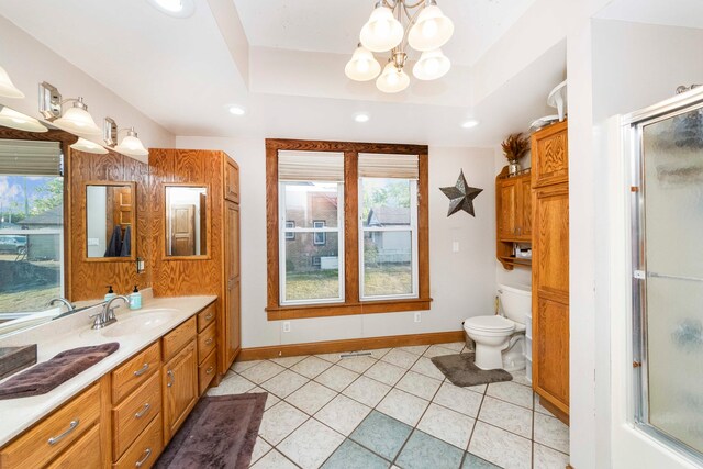 bathroom with a raised ceiling, a shower with door, a chandelier, toilet, and vanity