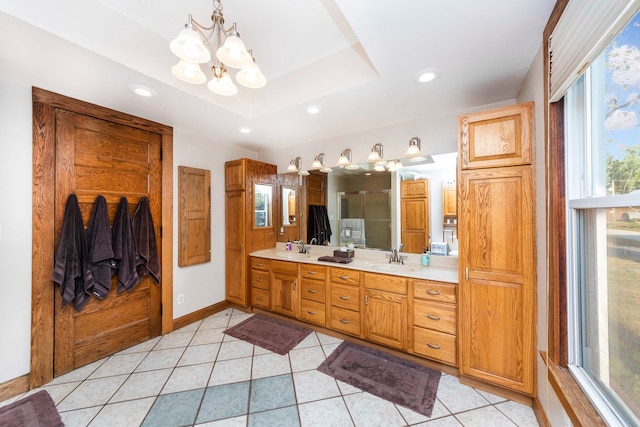 bathroom with a raised ceiling, an inviting chandelier, walk in shower, vanity, and tile patterned flooring