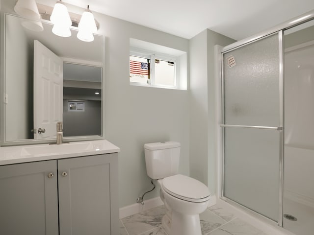 bathroom featuring vanity, toilet, and a shower with door