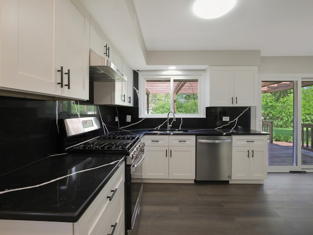 kitchen with white cabinets, stainless steel appliances, sink, and tasteful backsplash