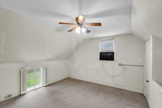 bonus room with a textured ceiling, vaulted ceiling, ceiling fan, and plenty of natural light