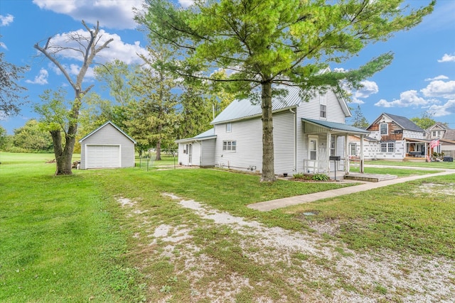 view of home's exterior with a lawn, an outdoor structure, a garage, and a porch