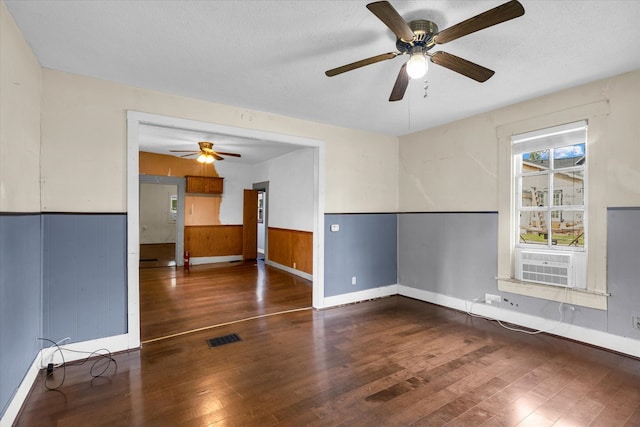 empty room featuring a textured ceiling, cooling unit, dark hardwood / wood-style floors, and ceiling fan