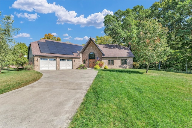 view of front of property with a garage, a front lawn, and solar panels