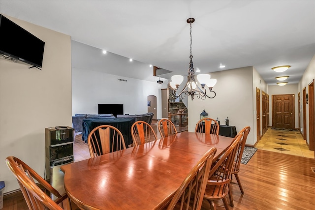 dining space featuring light wood-type flooring and a chandelier