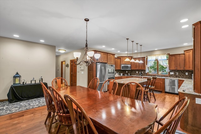 dining space with light wood-type flooring and a chandelier