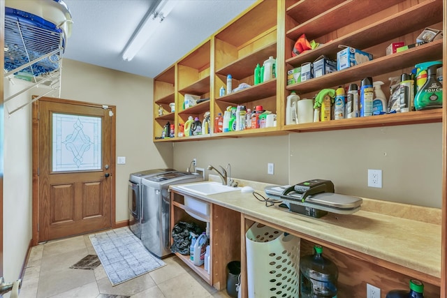 clothes washing area featuring light tile patterned flooring and washer and dryer