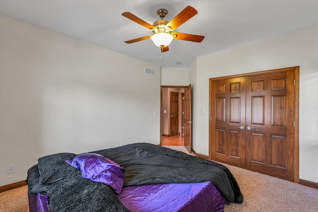 carpeted bedroom with ceiling fan and a closet