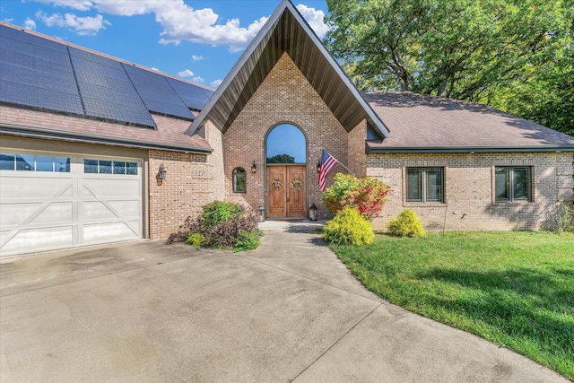 view of front facade with a garage, solar panels, and a front lawn