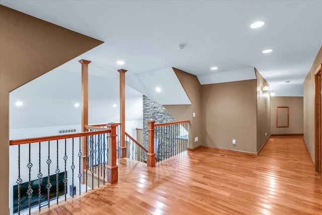 corridor featuring light hardwood / wood-style flooring and lofted ceiling