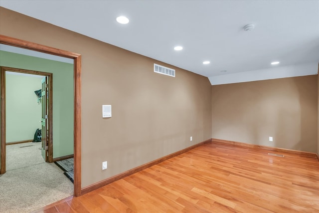 unfurnished room with light hardwood / wood-style floors and vaulted ceiling