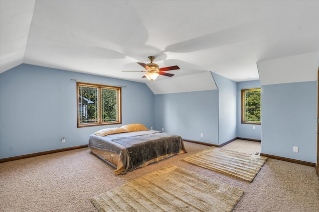 bedroom featuring ceiling fan, light colored carpet, lofted ceiling, and multiple windows