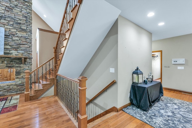 stairway featuring lofted ceiling and hardwood / wood-style flooring