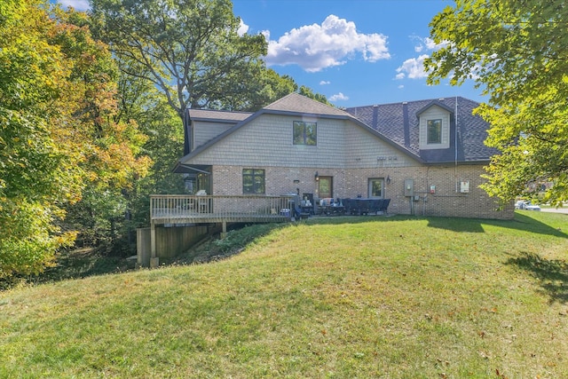 rear view of house with a lawn and a deck