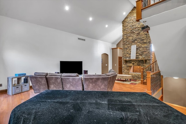 living room with high vaulted ceiling and hardwood / wood-style flooring