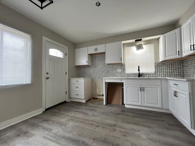 kitchen featuring backsplash, light hardwood / wood-style floors, white cabinetry, and sink