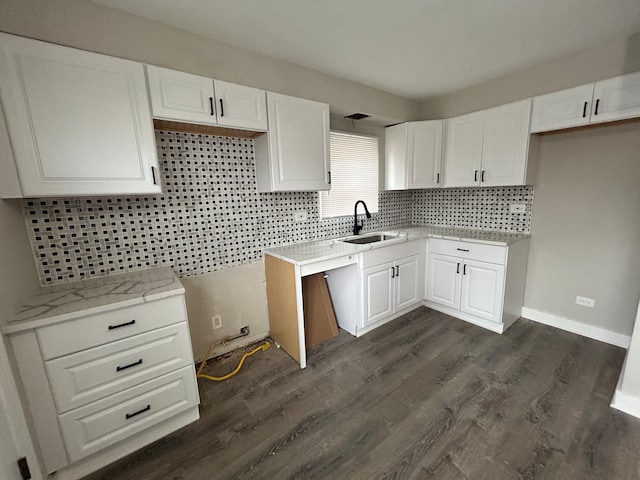 kitchen with decorative backsplash, white cabinetry, dark wood-type flooring, and sink