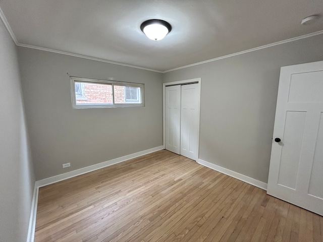 unfurnished bedroom with ornamental molding, light hardwood / wood-style flooring, and a closet