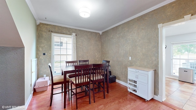 dining area with light wood-type flooring and crown molding