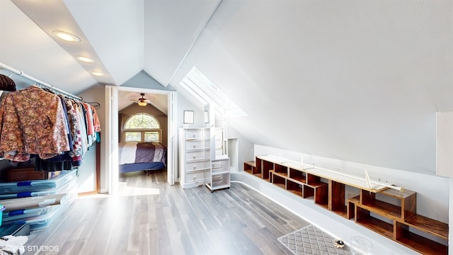 interior space featuring ceiling fan, lofted ceiling, and light wood-type flooring