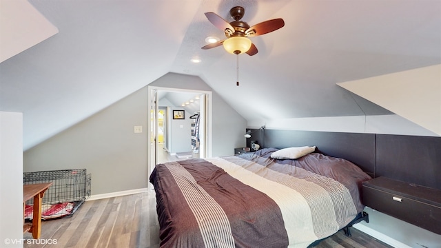 bedroom featuring wood-type flooring, vaulted ceiling, and ceiling fan