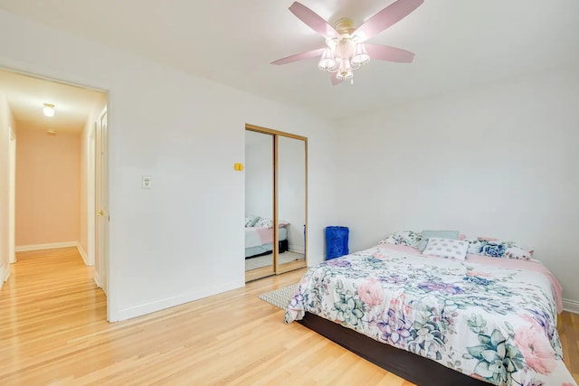 bedroom with hardwood / wood-style floors, ceiling fan, and a closet