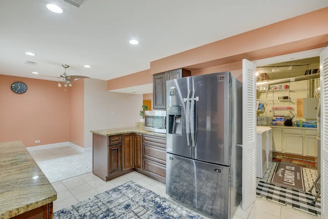 kitchen featuring kitchen peninsula, stainless steel appliances, light tile patterned floors, light stone countertops, and ceiling fan