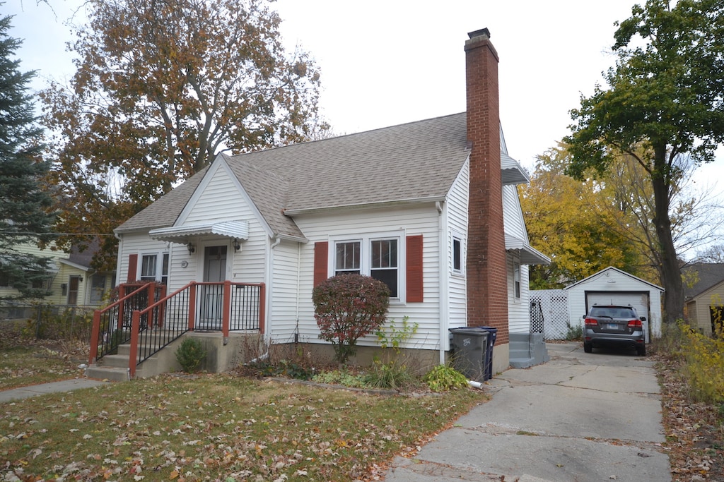 view of front of home with an outdoor structure, a front yard, and a garage