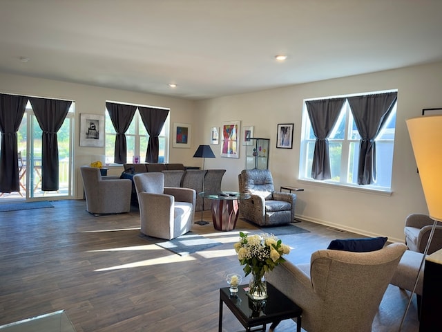 living room with a wealth of natural light and dark wood-type flooring