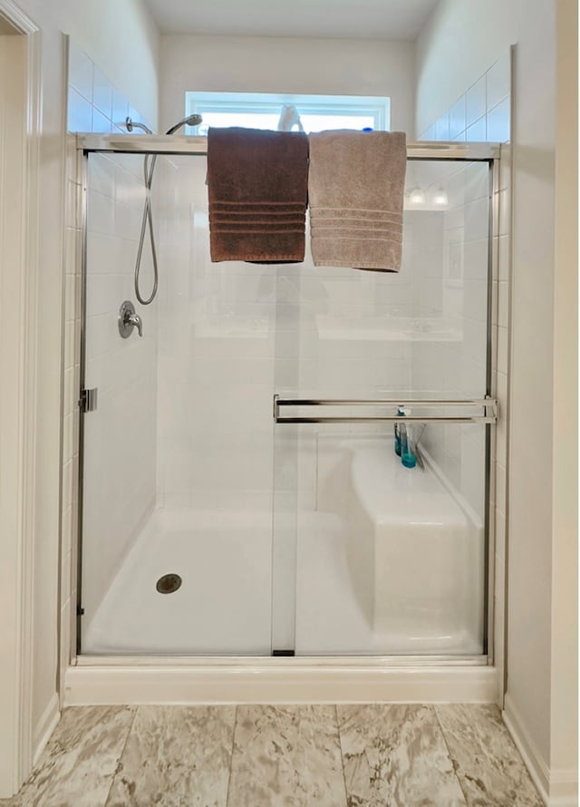 bathroom with a shower with door