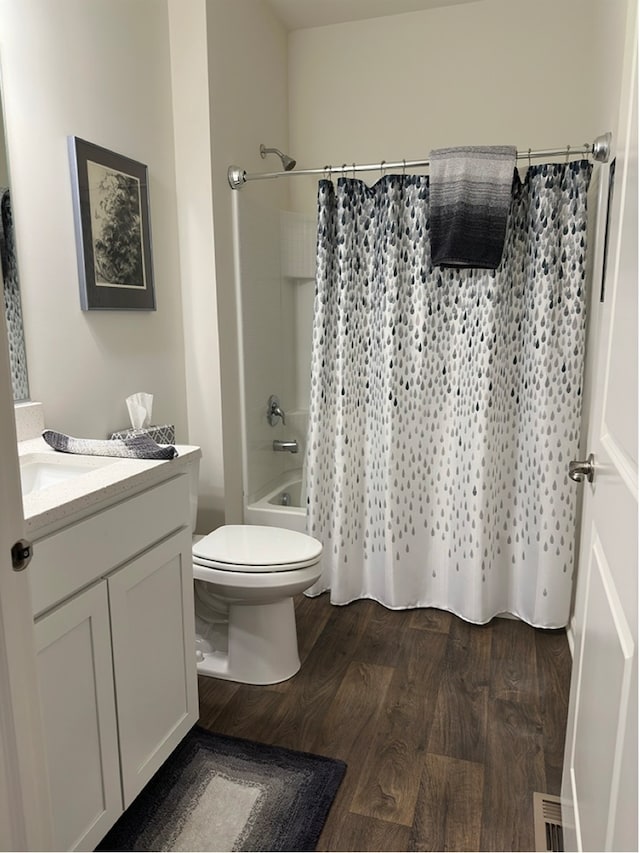 full bathroom featuring shower / bath combo with shower curtain, hardwood / wood-style flooring, vanity, and toilet