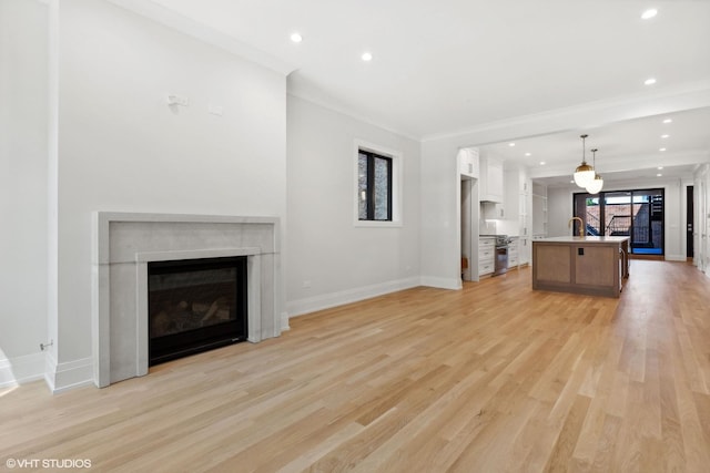 unfurnished living room with light hardwood / wood-style floors, plenty of natural light, and crown molding