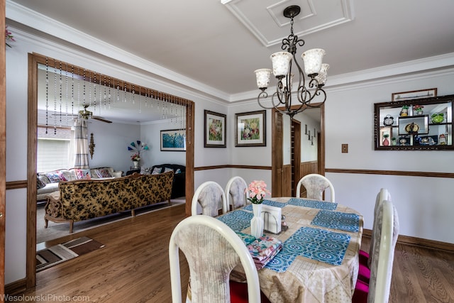 dining room with crown molding, dark hardwood / wood-style flooring, and a chandelier