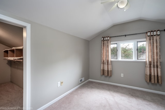 interior space featuring a closet, lofted ceiling, carpet, a spacious closet, and ceiling fan