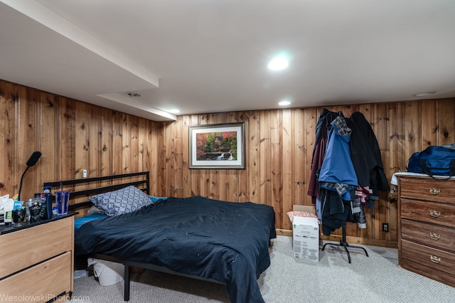 carpeted bedroom featuring wood walls