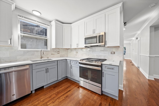 kitchen featuring a wealth of natural light, stainless steel appliances, dark hardwood / wood-style flooring, and gray cabinetry