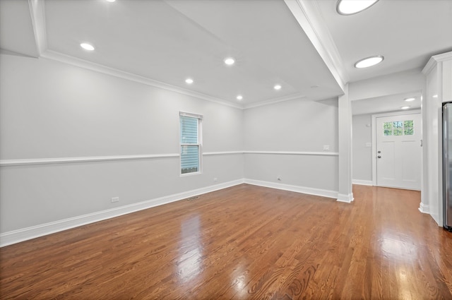 spare room with wood-type flooring and crown molding