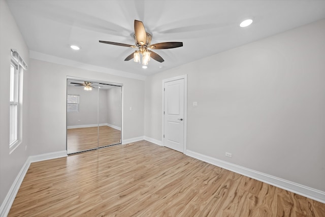 unfurnished bedroom featuring light hardwood / wood-style flooring, ceiling fan, and multiple windows