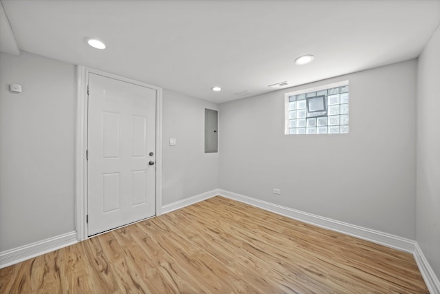 empty room featuring electric panel and hardwood / wood-style floors