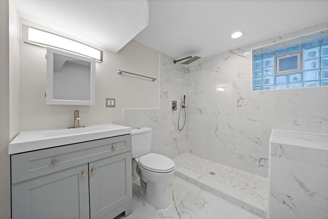 bathroom featuring vanity, a tile shower, and toilet