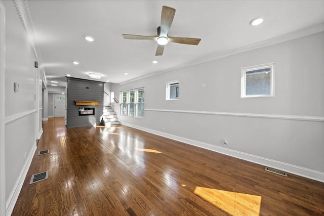 unfurnished living room with dark wood-type flooring, ceiling fan, a fireplace, and crown molding